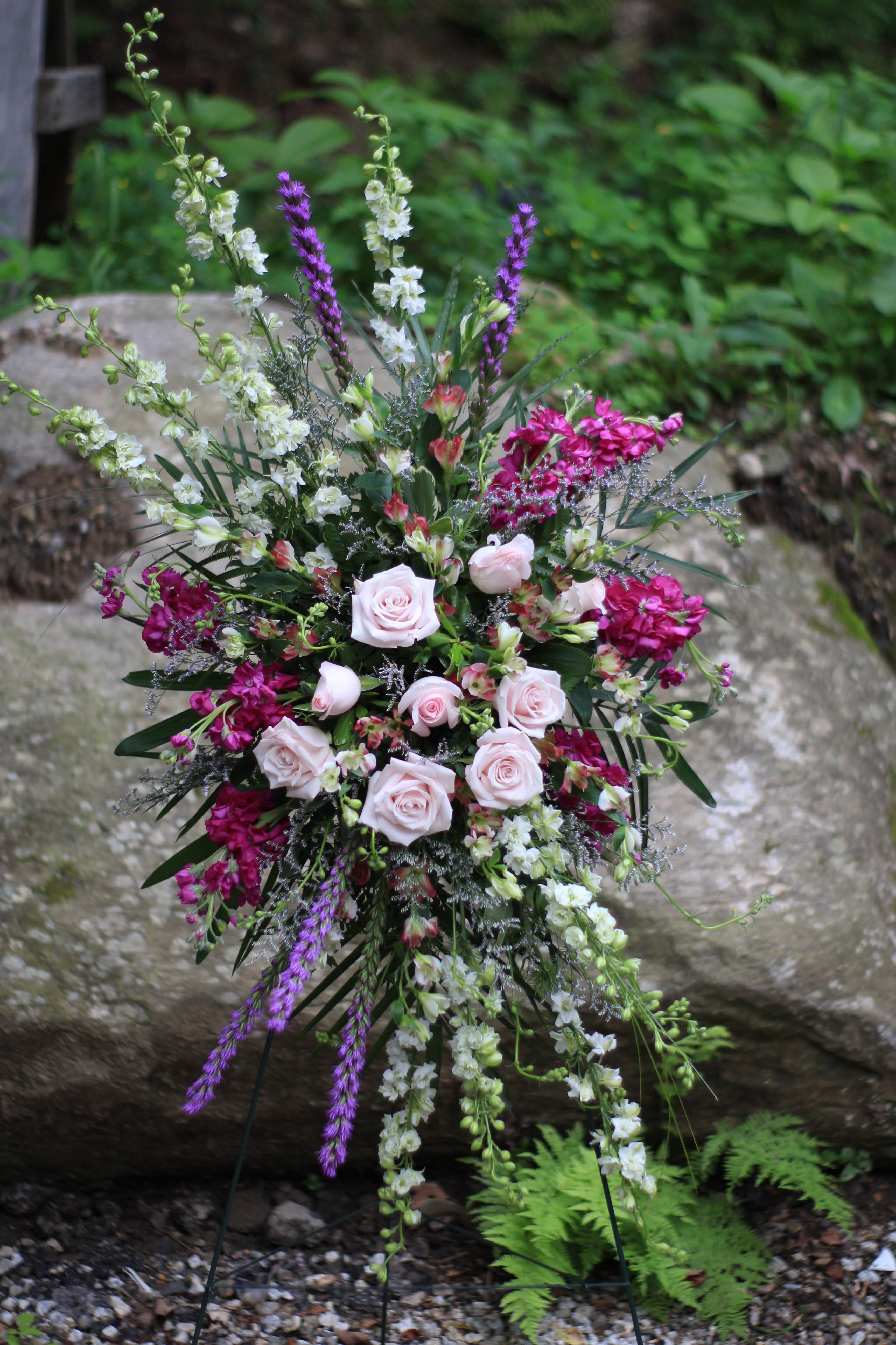 Tall floral spray with pale pink roses and purple and white blooms
