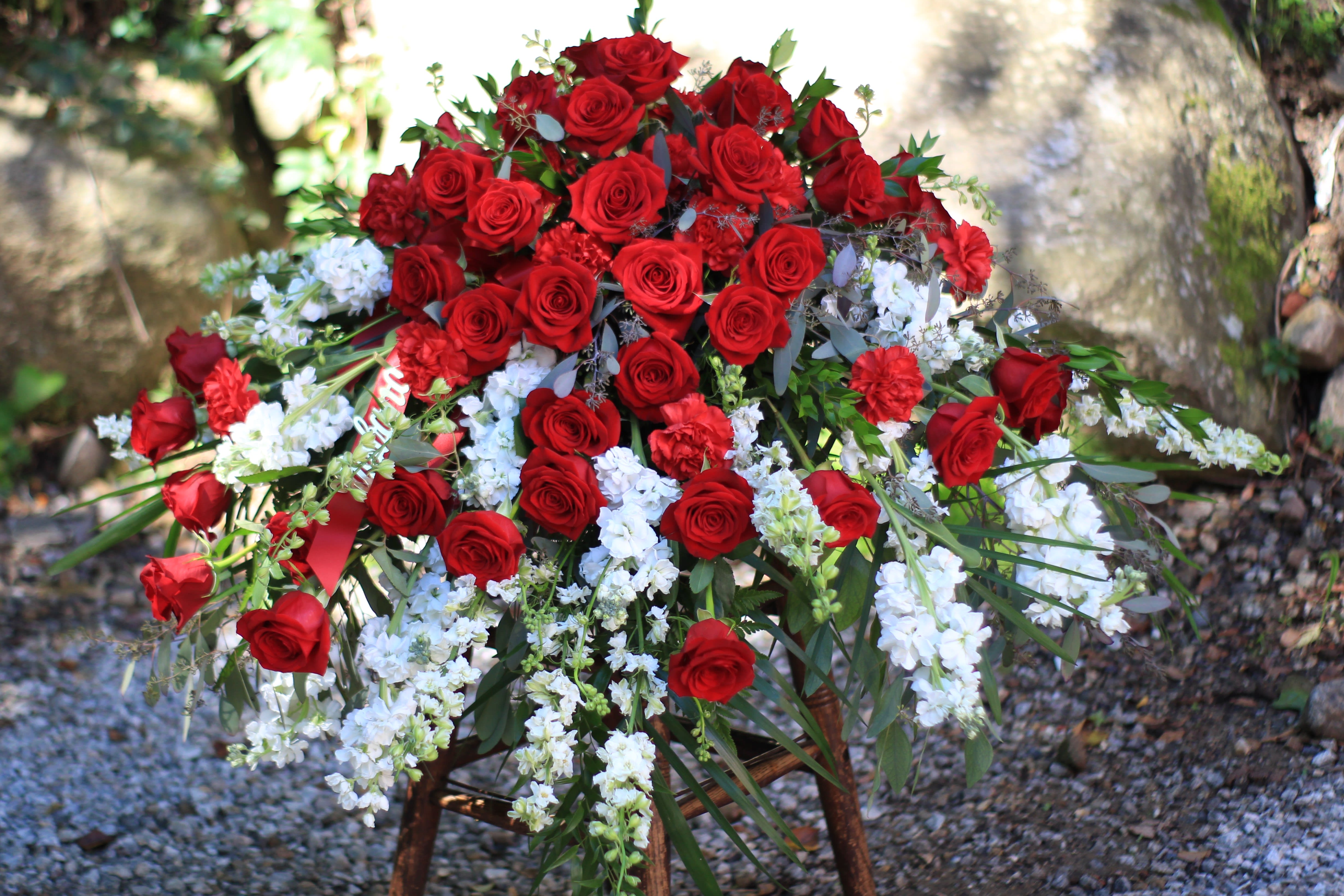 Large arrangement of red roses with white flowers outdoors