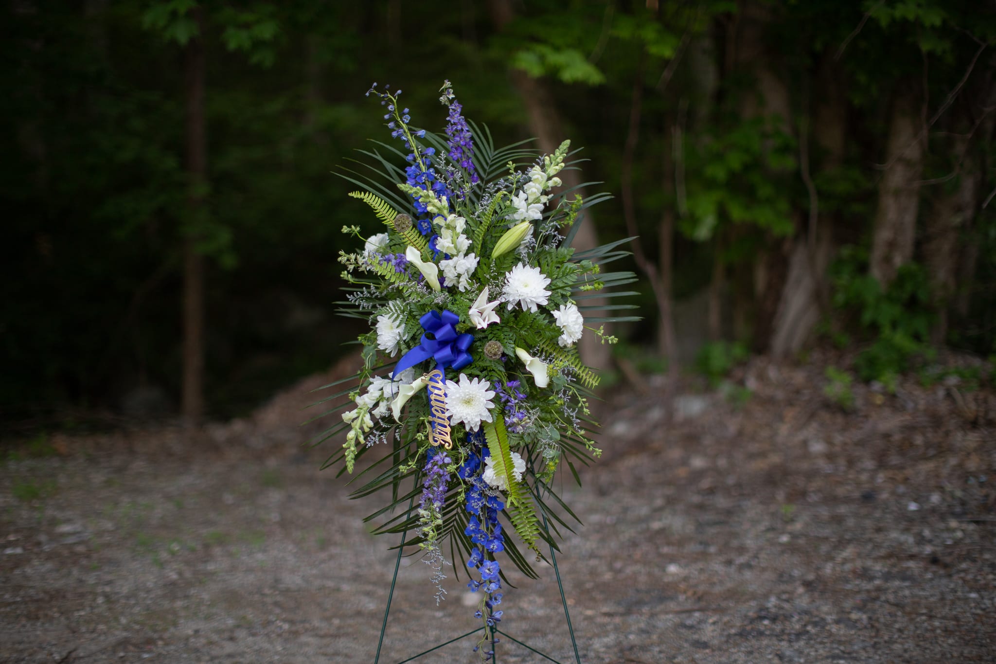 Tall standing floral spray with white and blue flowers on an easel