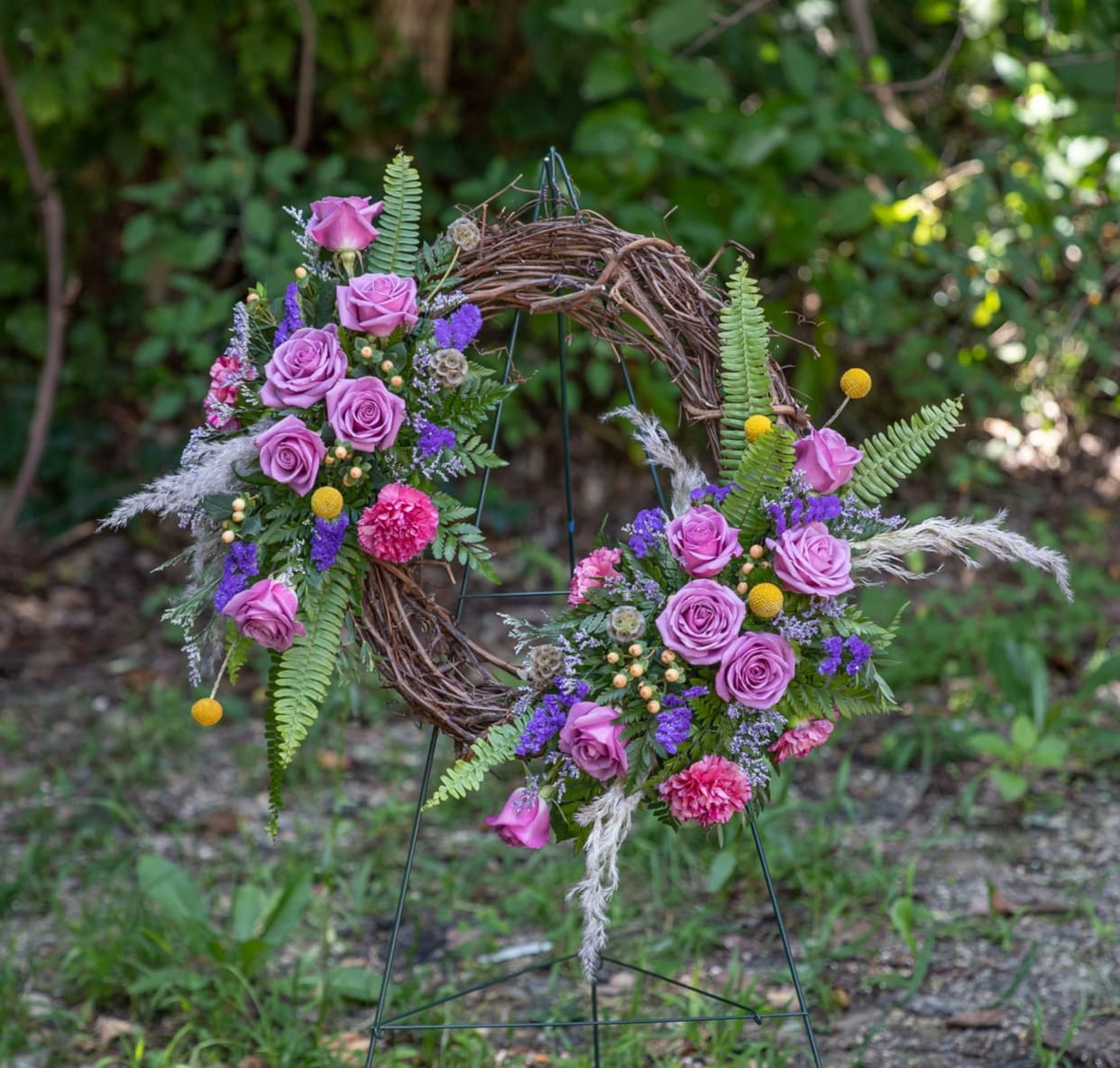 Floral wreath with pink roses and purple flowers on a twig frame