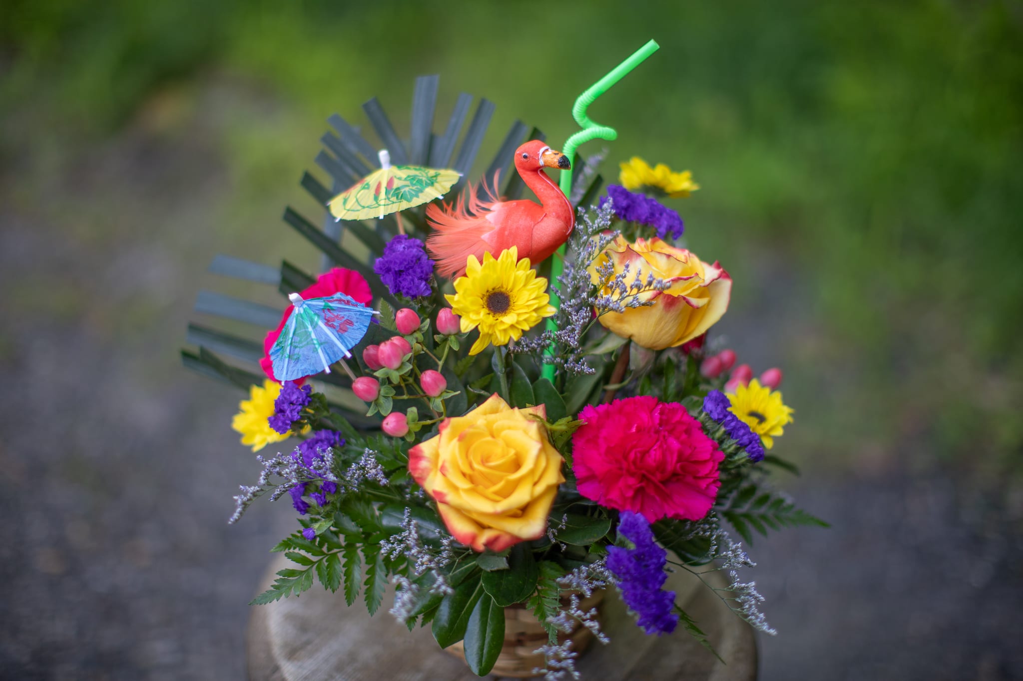 Tropical bouquet with roses, sunflower, carnation, and flamingo decoration