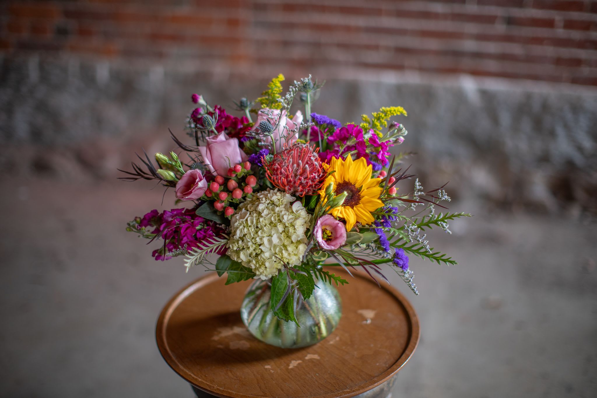 Mixed bouquet in a glass vase with a sunflower and pink blooms