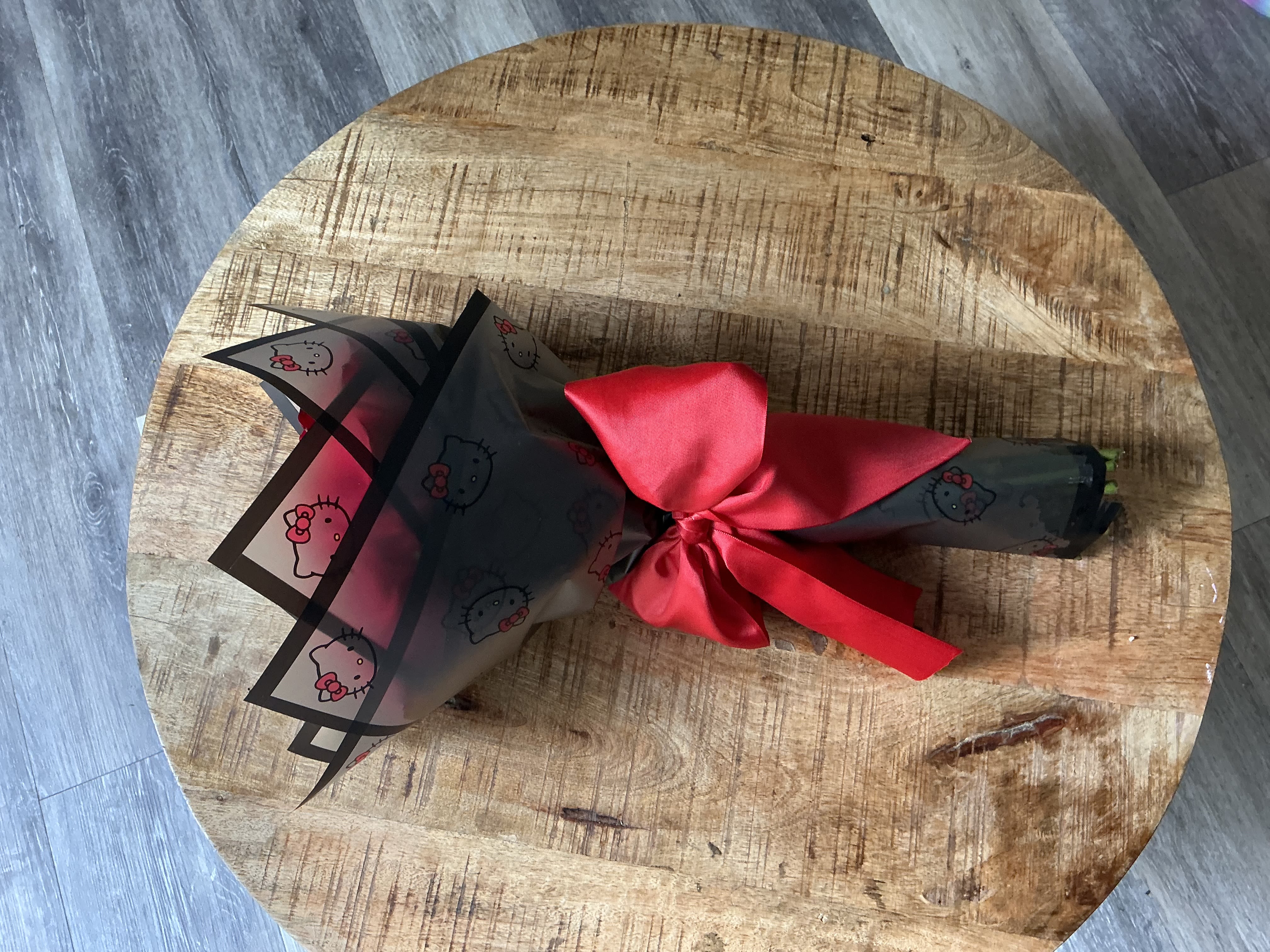 Wrapped bouquet tied with a red satin ribbon