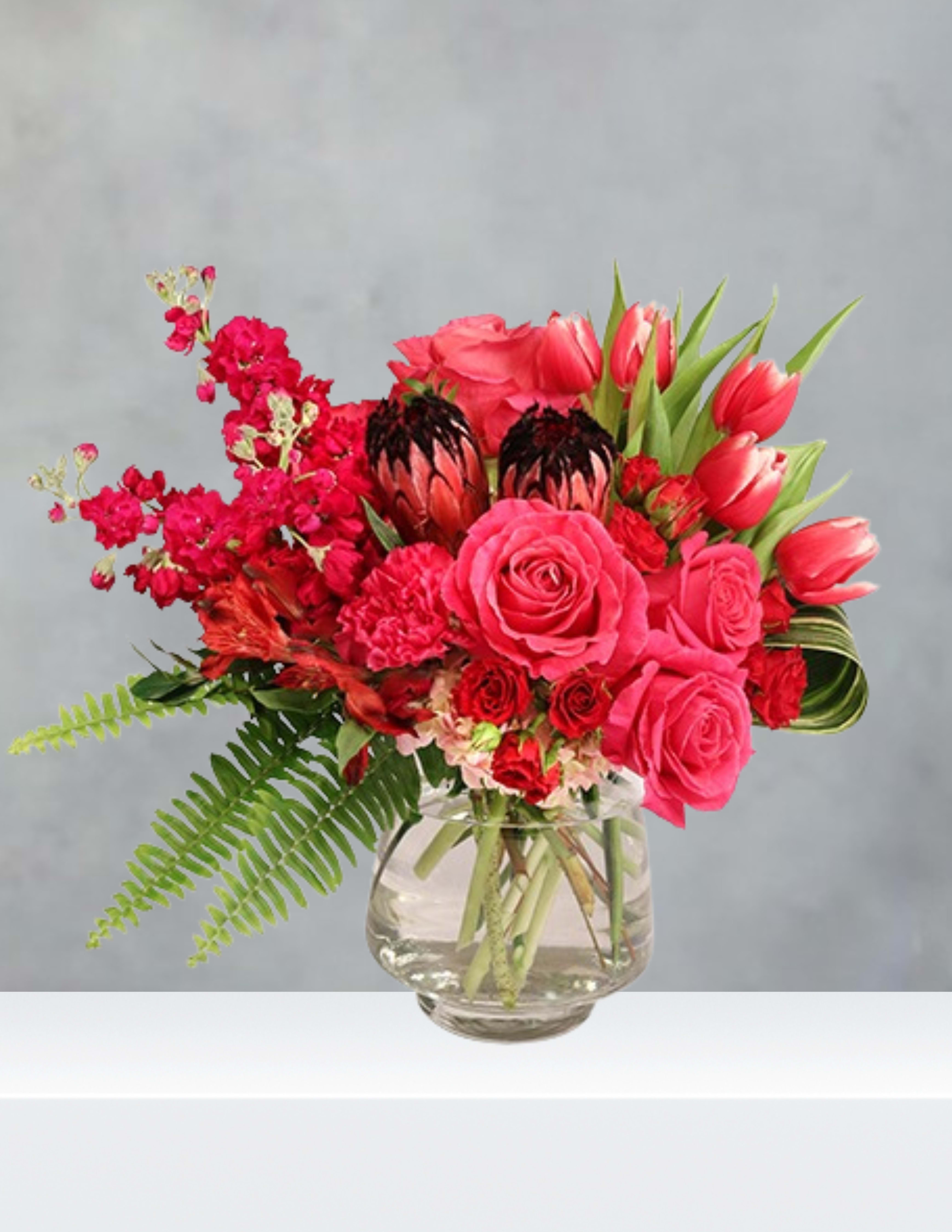 Pink and red mixed bouquet in a clear glass vase