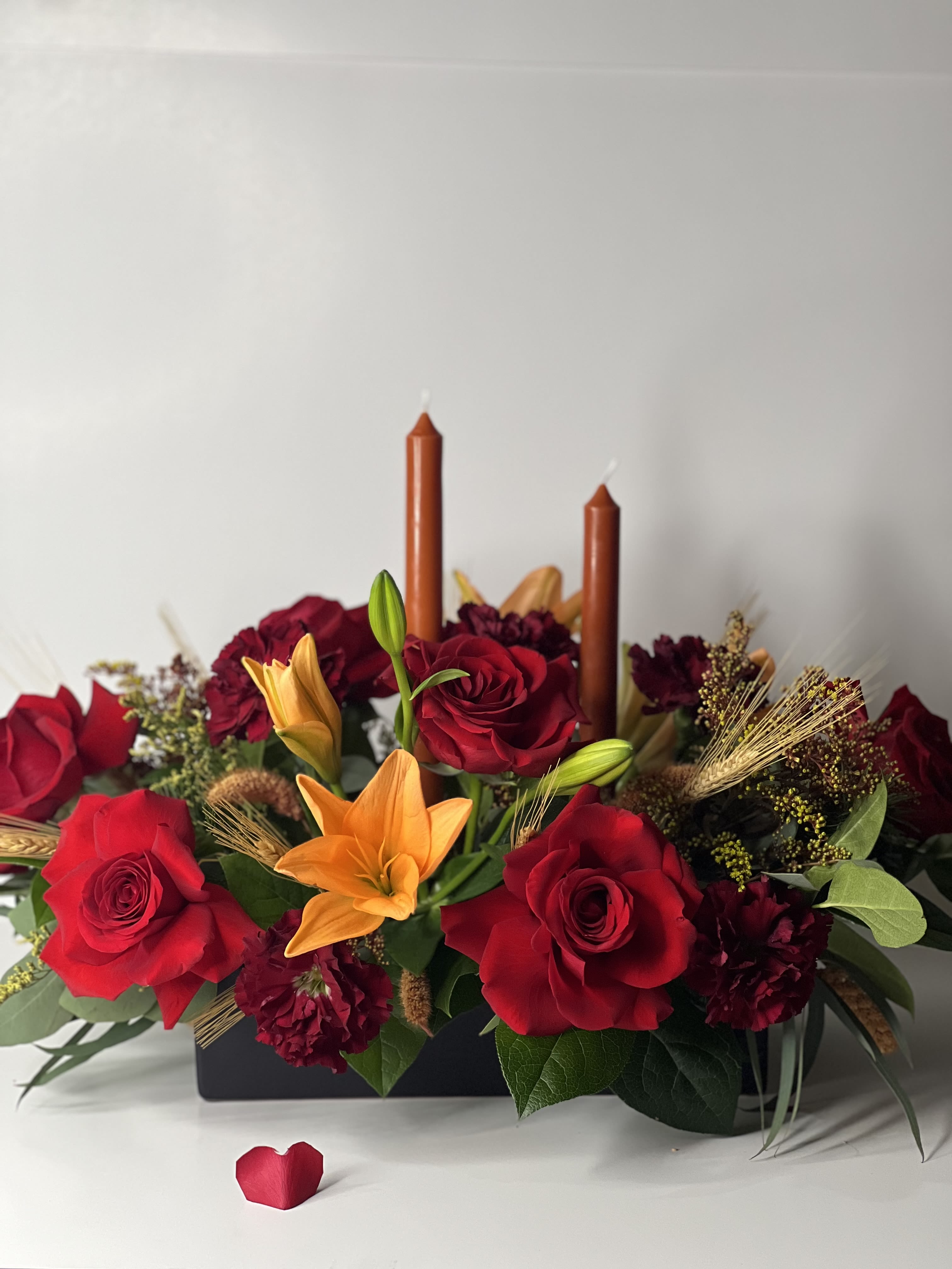 THANKFUL CENTERPIECE  - This arrangement is made with red roses, orange lily’s, carnations and mix greens. This  centerpiece is the perfect addition for the Thanksgiving table or sending a special "Thank You" to the host. 