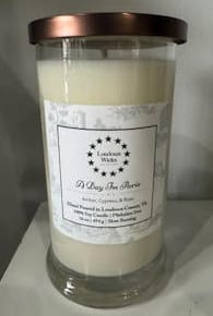 Large cream-colored candle in a glass jar with a metal lid