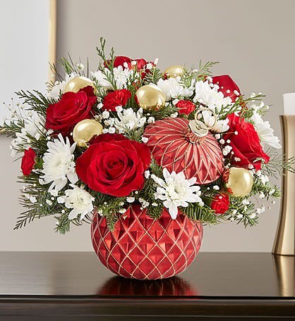 Red roses and white daisies in a red patterned vase with gold ornaments