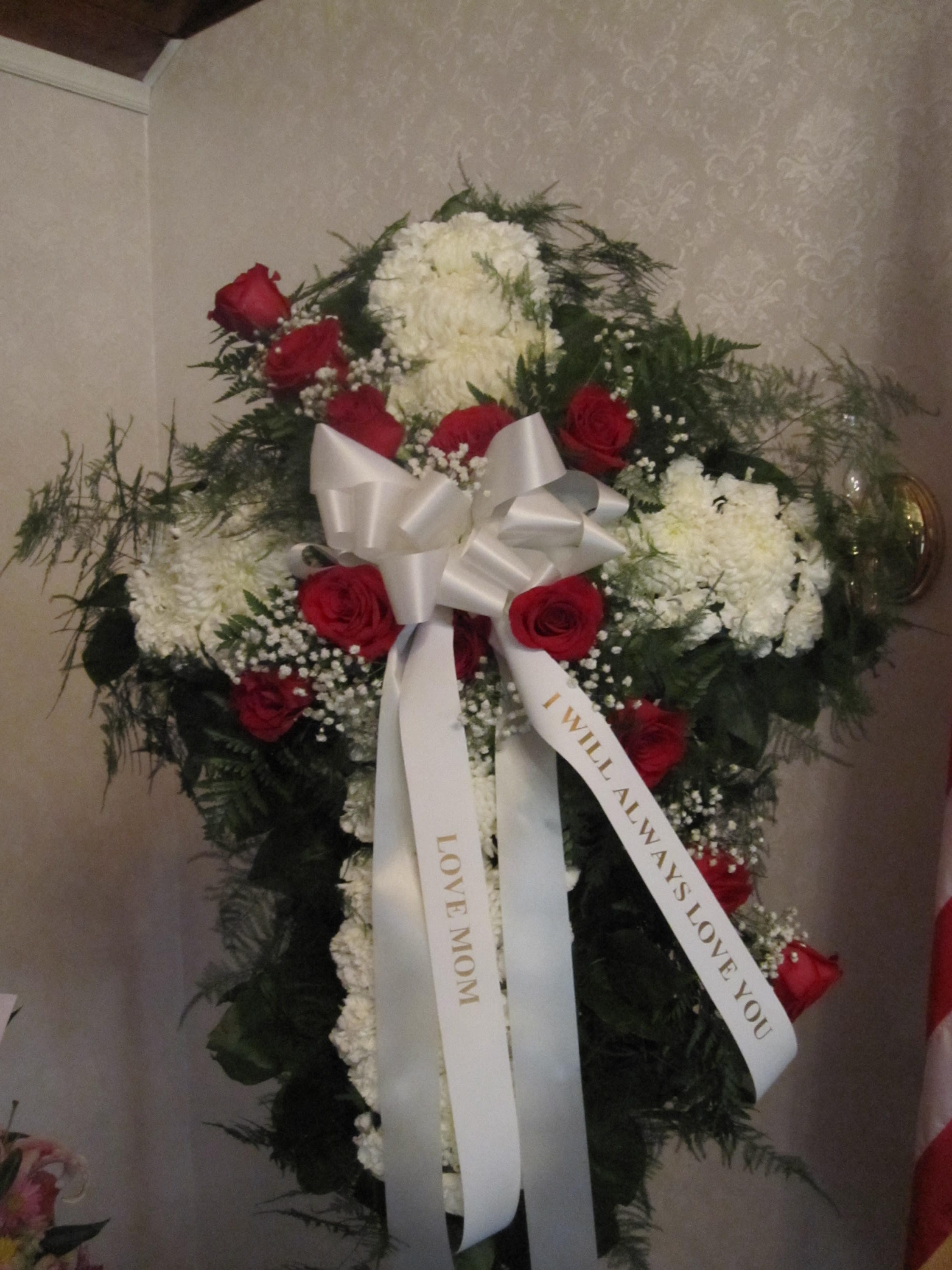 Standing floral spray with red roses, white blooms, and a white ribbon