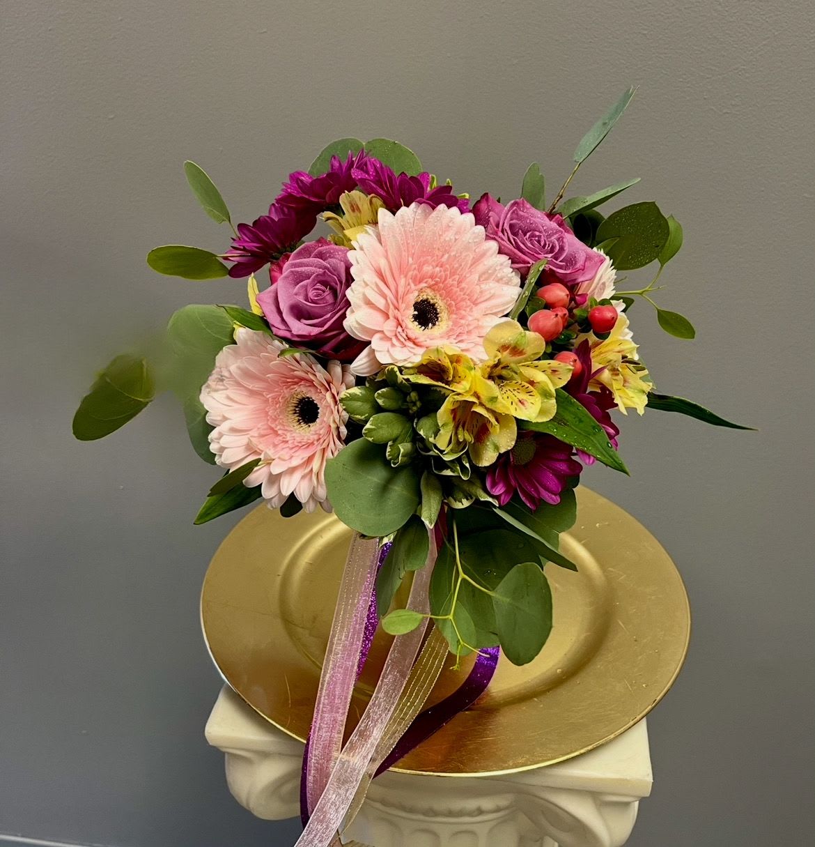 Bouquet of pink gerbera daisies, purple roses, and yellow alstroemeria