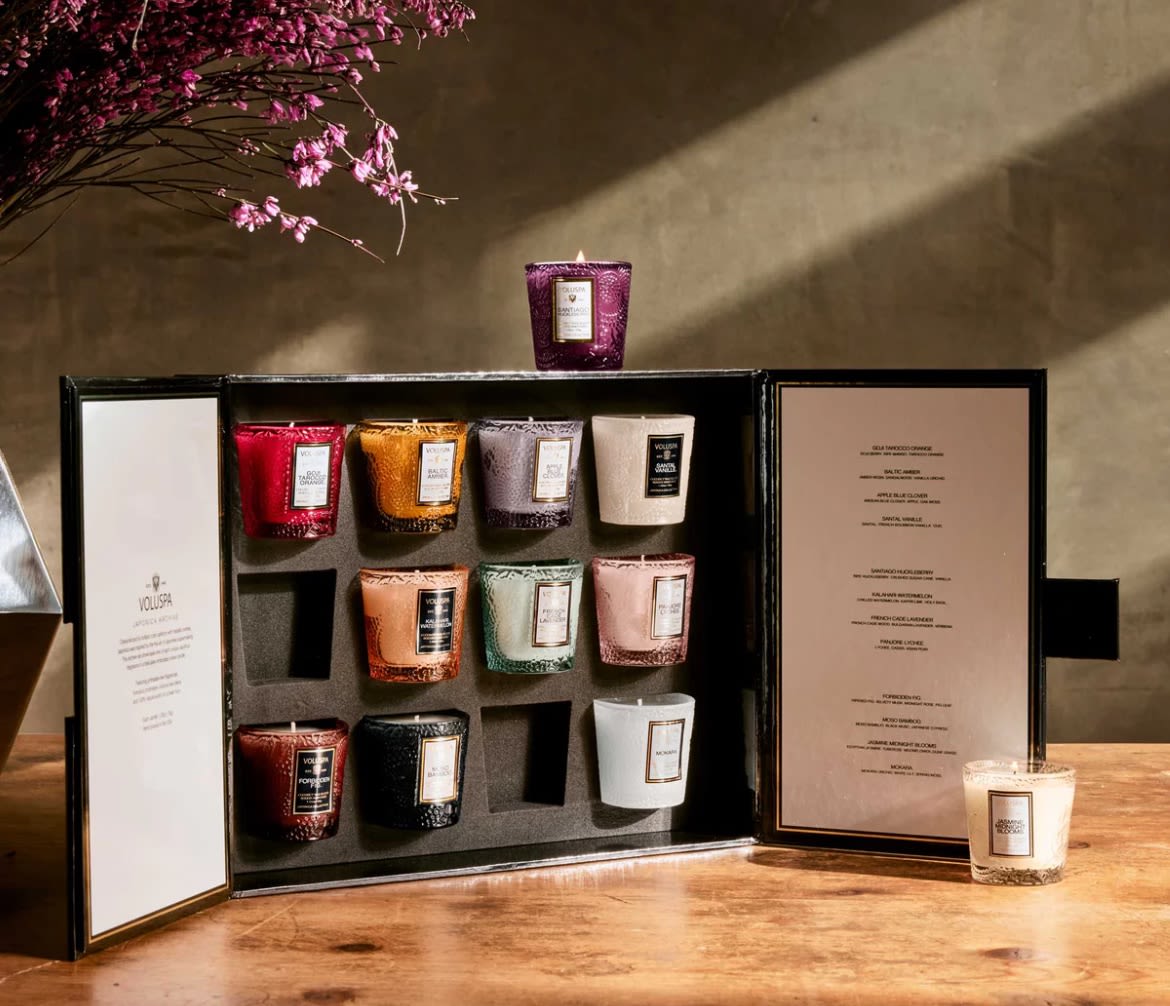 Voluspa Japonica Archive 12 Votive Gift Set - 12 votives of Voluspa's most popular scents including Goji Tarocco Orange, Baltic Amber, Apple Blue Clover, Santal Vanille, Santiago Huckleberry, Kalahari Watermelon, French Cade Lavender, Panjore Lychee, Forbidden Fig, Moso Bamboo, Jasmine Midnight Blooms, and Mokara. 