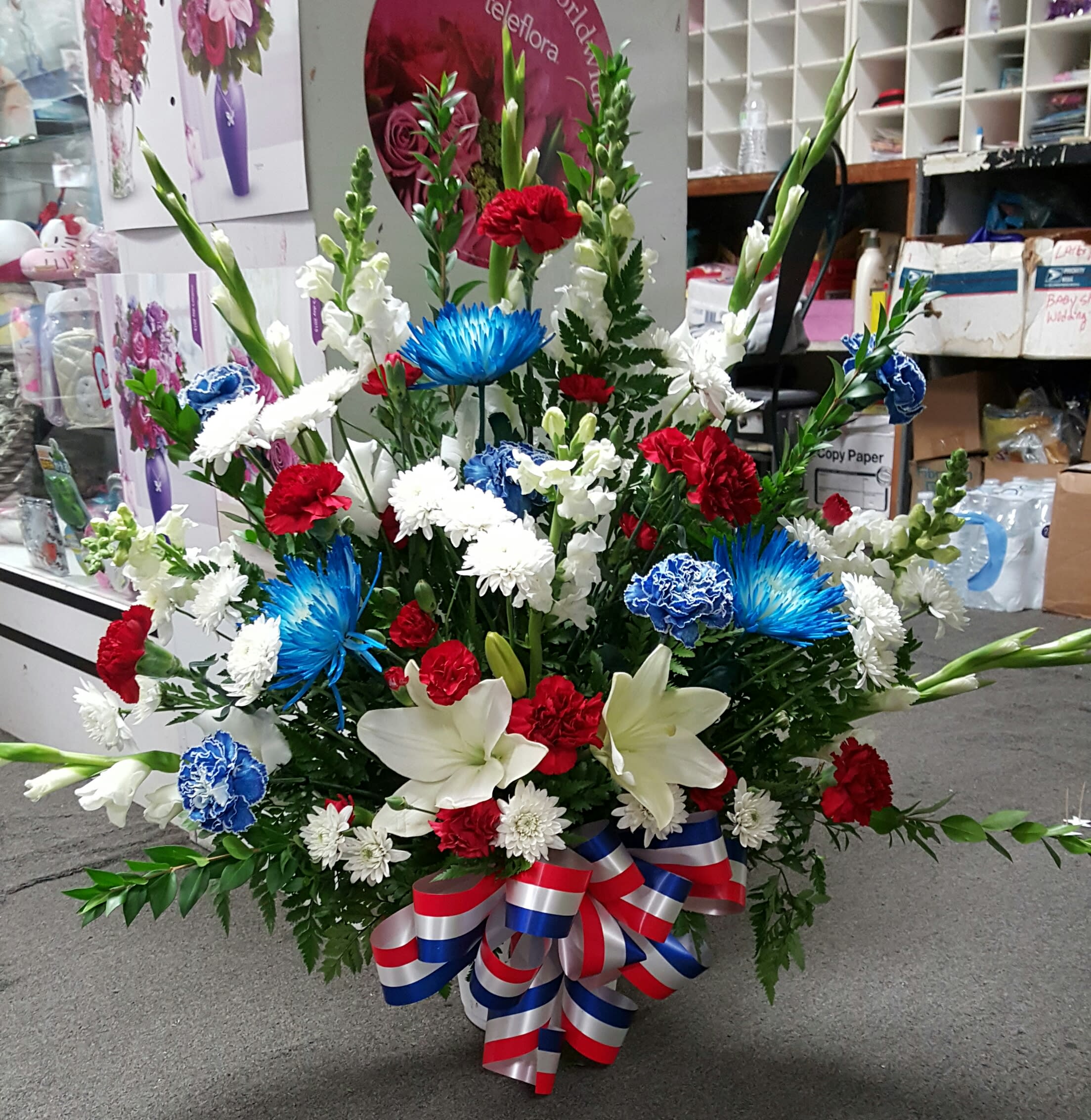 Large red, white, and blue floral arrangement with lilies and carnations