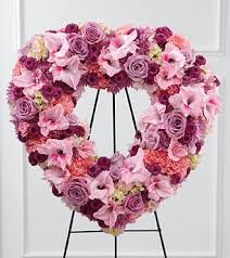 Heart-shaped floral wreath in pink and purple tones on a stand
