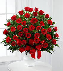 Bouquet of red roses with a red ribbon in a white vase