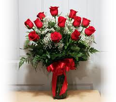 Bouquet of red roses in a glass vase with a red ribbon