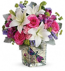 Pink and white flower arrangement in a decorative square vase
