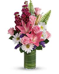 Pink lilies and roses in a green vase with white daisies