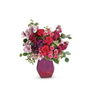 Bouquet of pink and red flowers in a purple vase