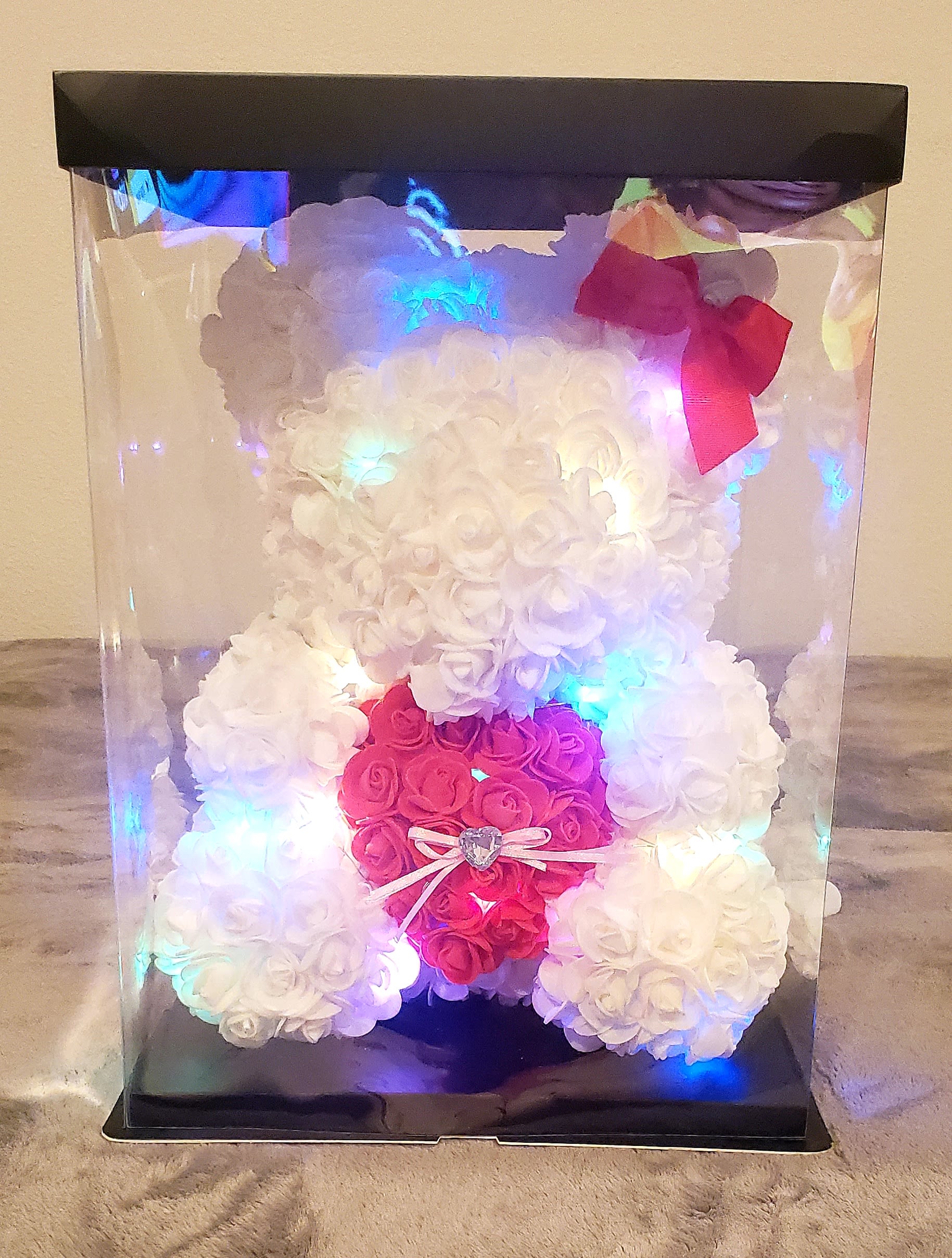 White and pink rose teddy bear in a clear display box with a bow