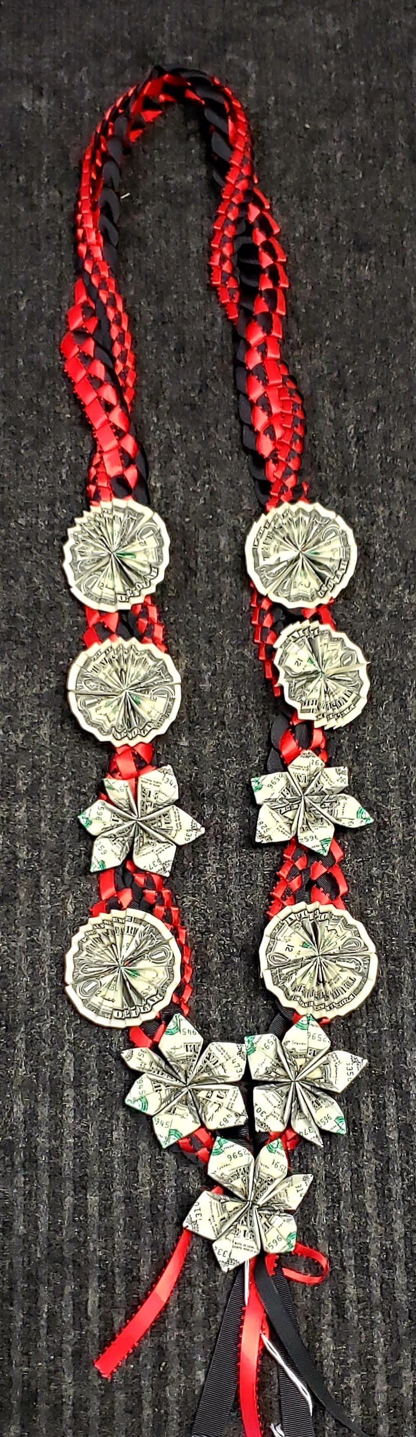 Braided red and black ribbon necklace with folded paper flower and coin-like medallions