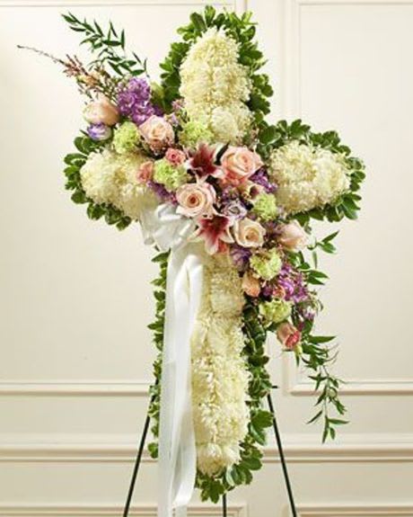 Standing floral spray with white and pastel flowers on a white ribboned easel