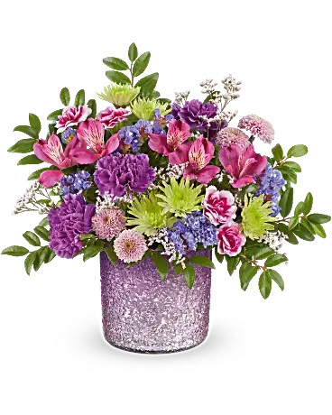 Mixed bouquet in a glittery purple vase with pink, purple, and green flowers