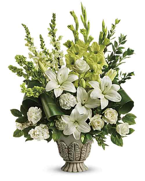 White lilies and roses in a decorative pedestal vase with green accents