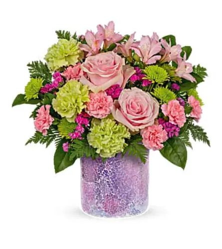 Pink roses and mixed blooms arranged in a purple vase