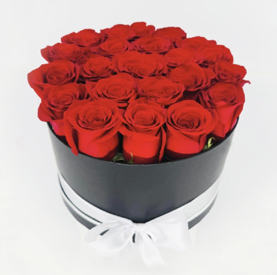 Red roses arranged in a black round box with a white ribbon