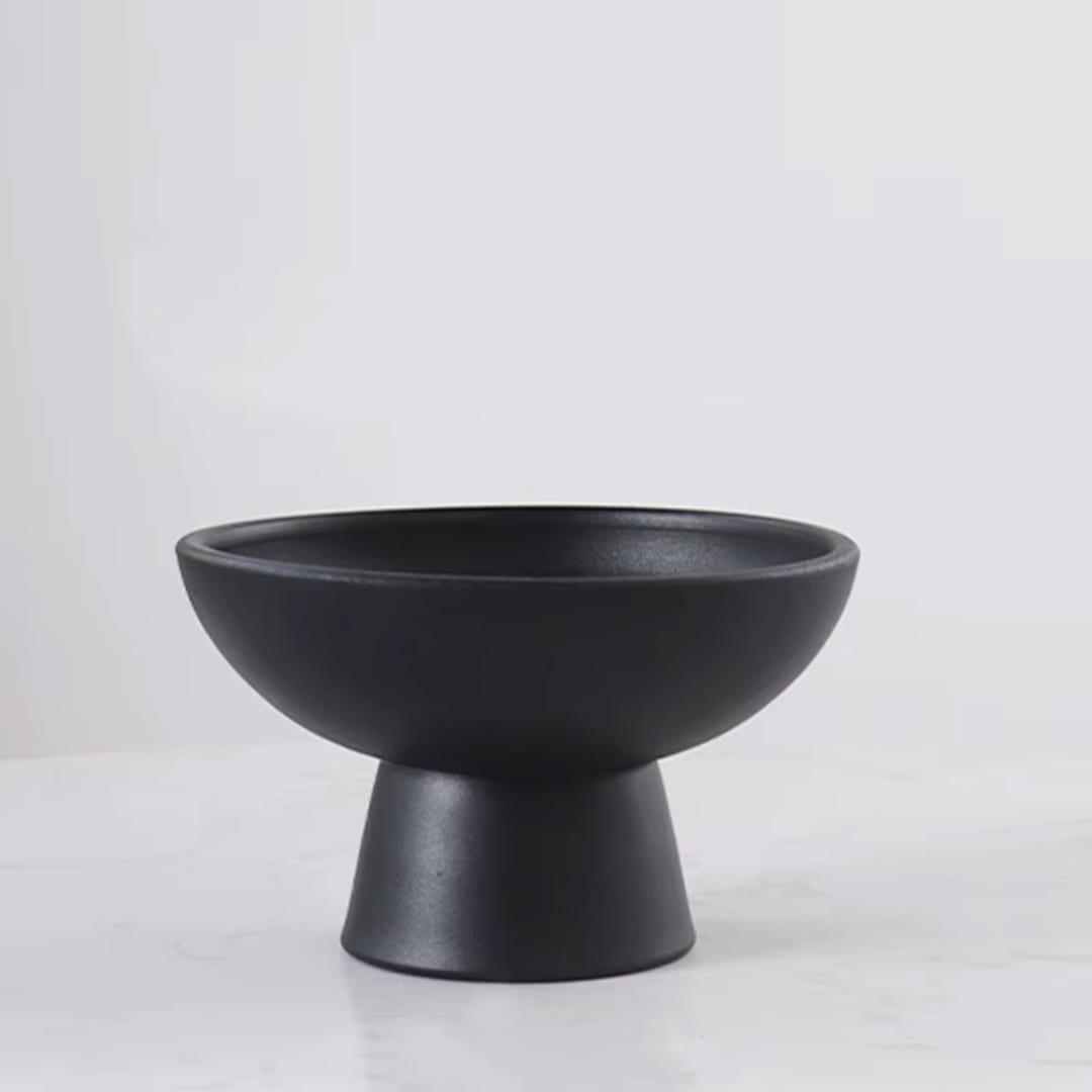 Black pedestal bowl vase on a white surface