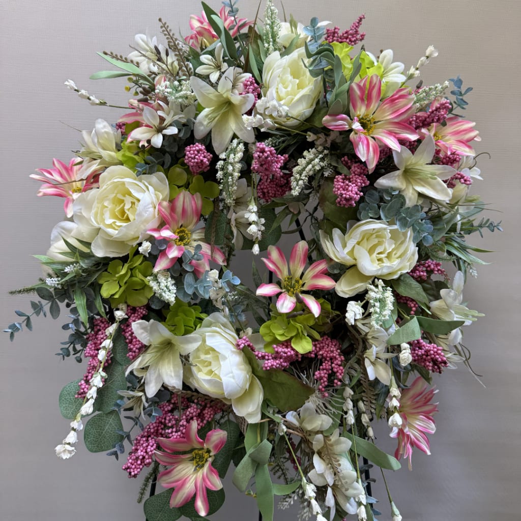 Large floral wreath with white and pink flowers and mixed greenery