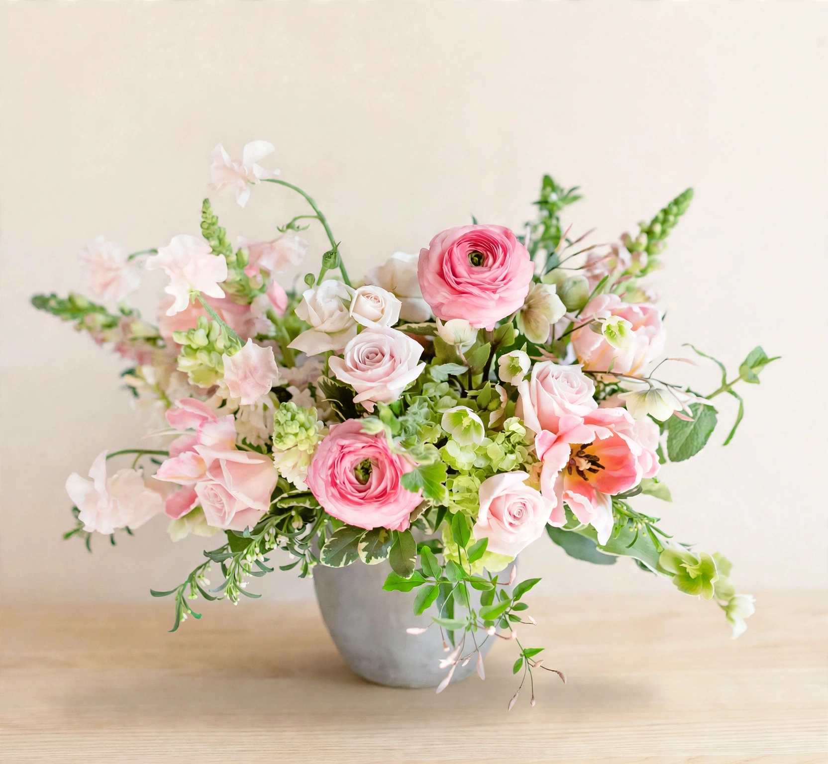 Pink and white floral arrangement in a gray vase