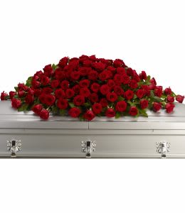 Large red rose casket spray on a white casket