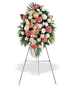 Standing funeral spray of pink and white flowers on an easel
