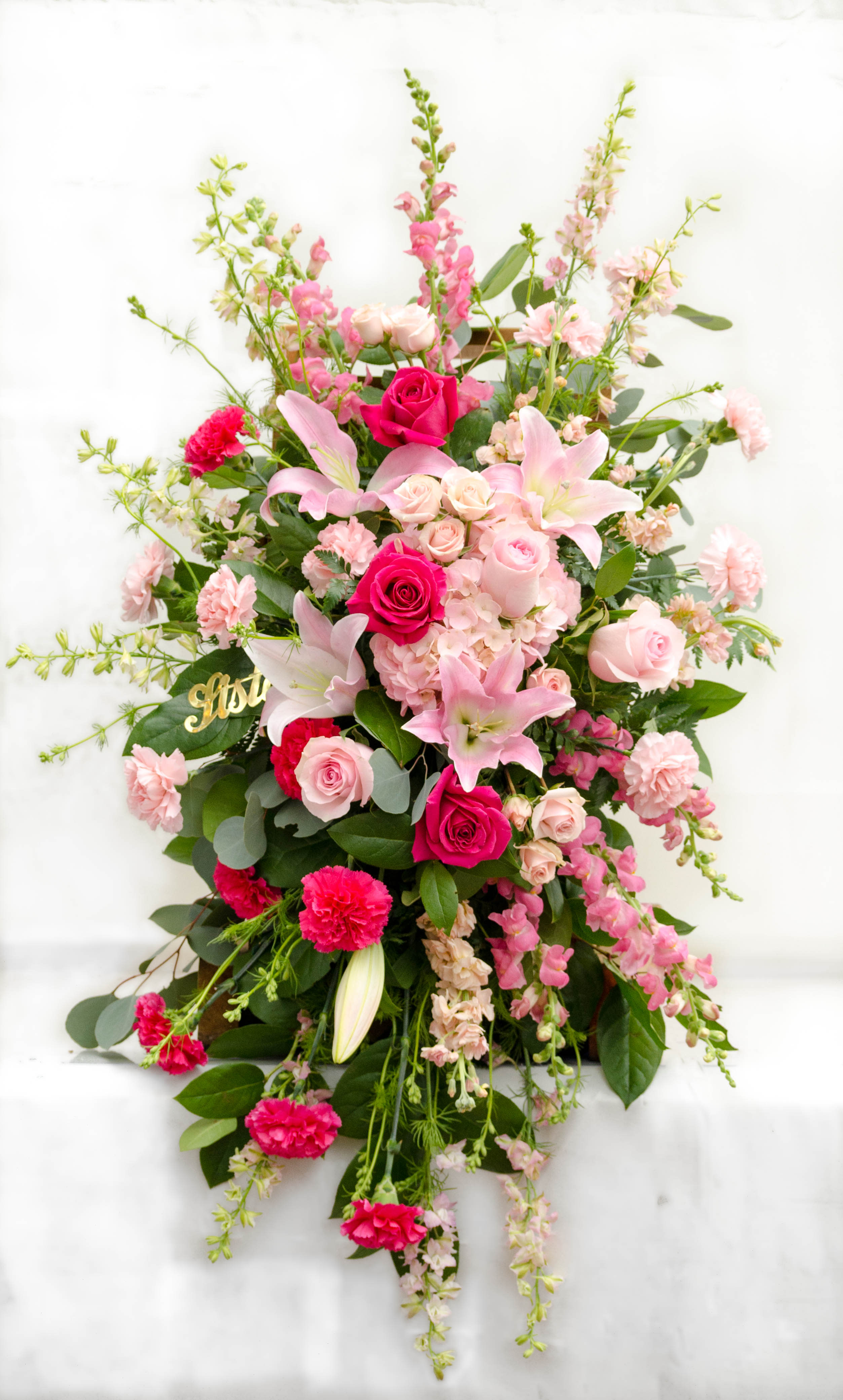Tall pink floral arrangement with roses and lilies