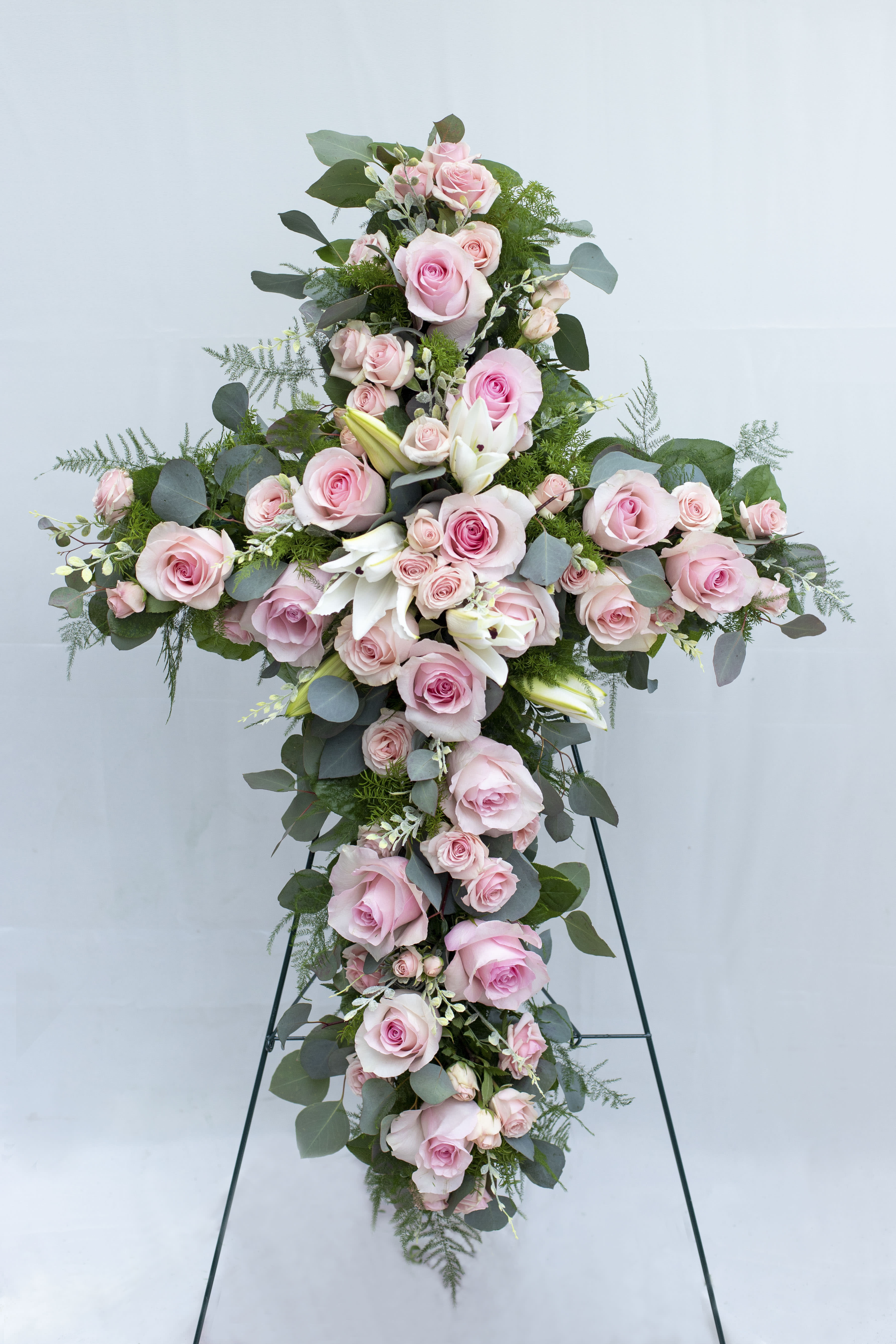 Tall cross-shaped floral spray with pink roses and white lilies