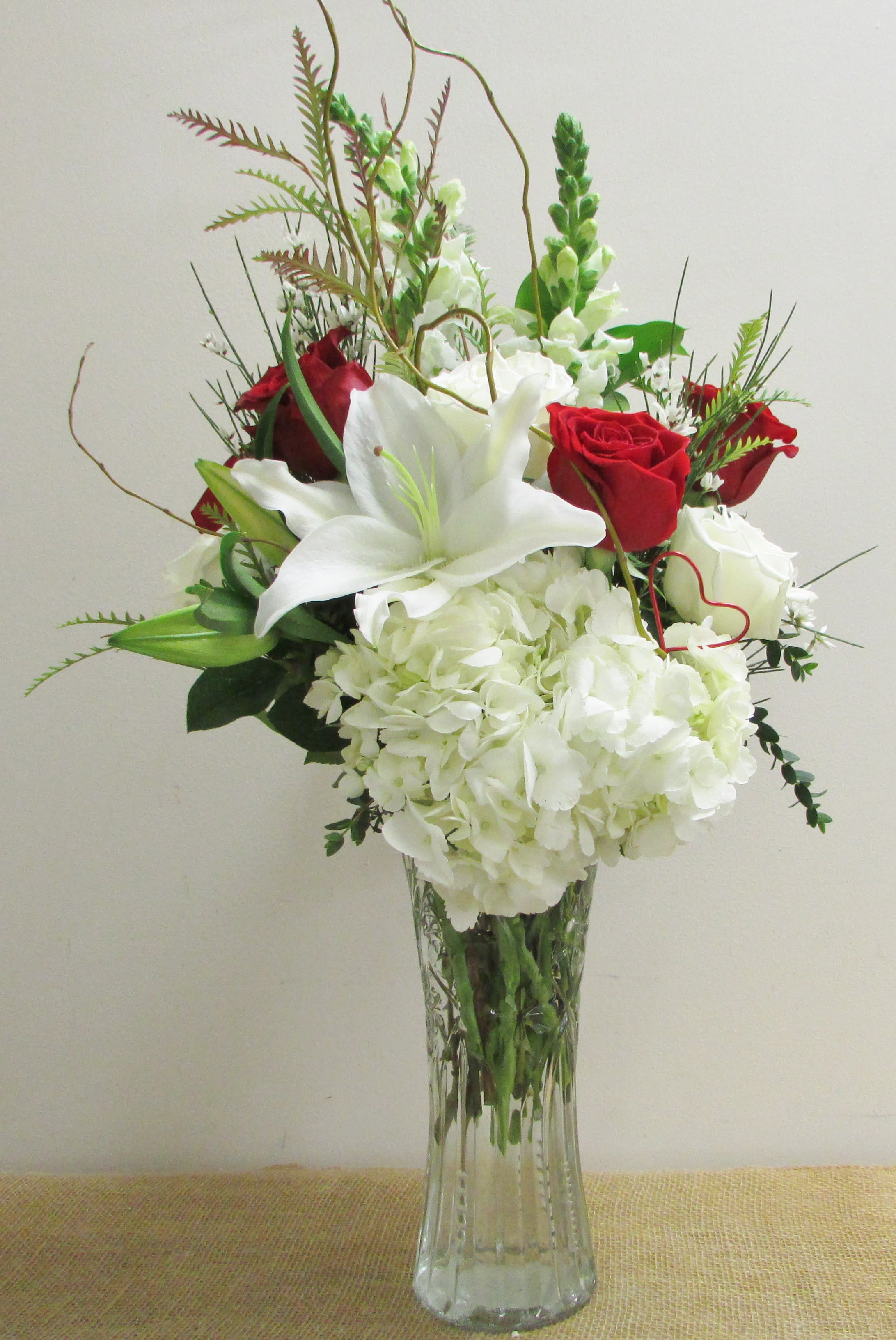 Be Mine - A Valentine's mix of red white and red roses, perfectly accented with a heart arranged in a tall vase.