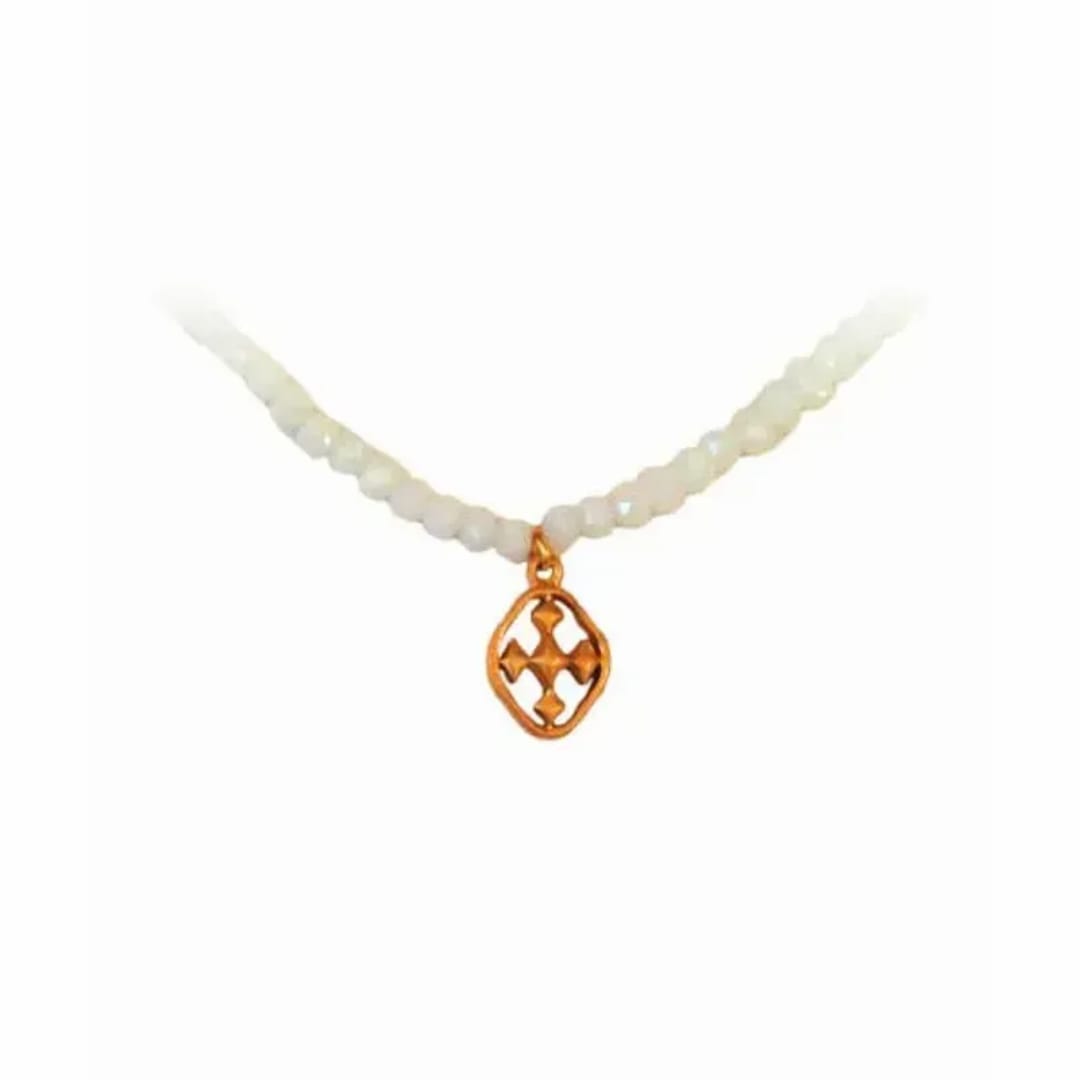 White beaded necklace with a gold pendant on a plain background