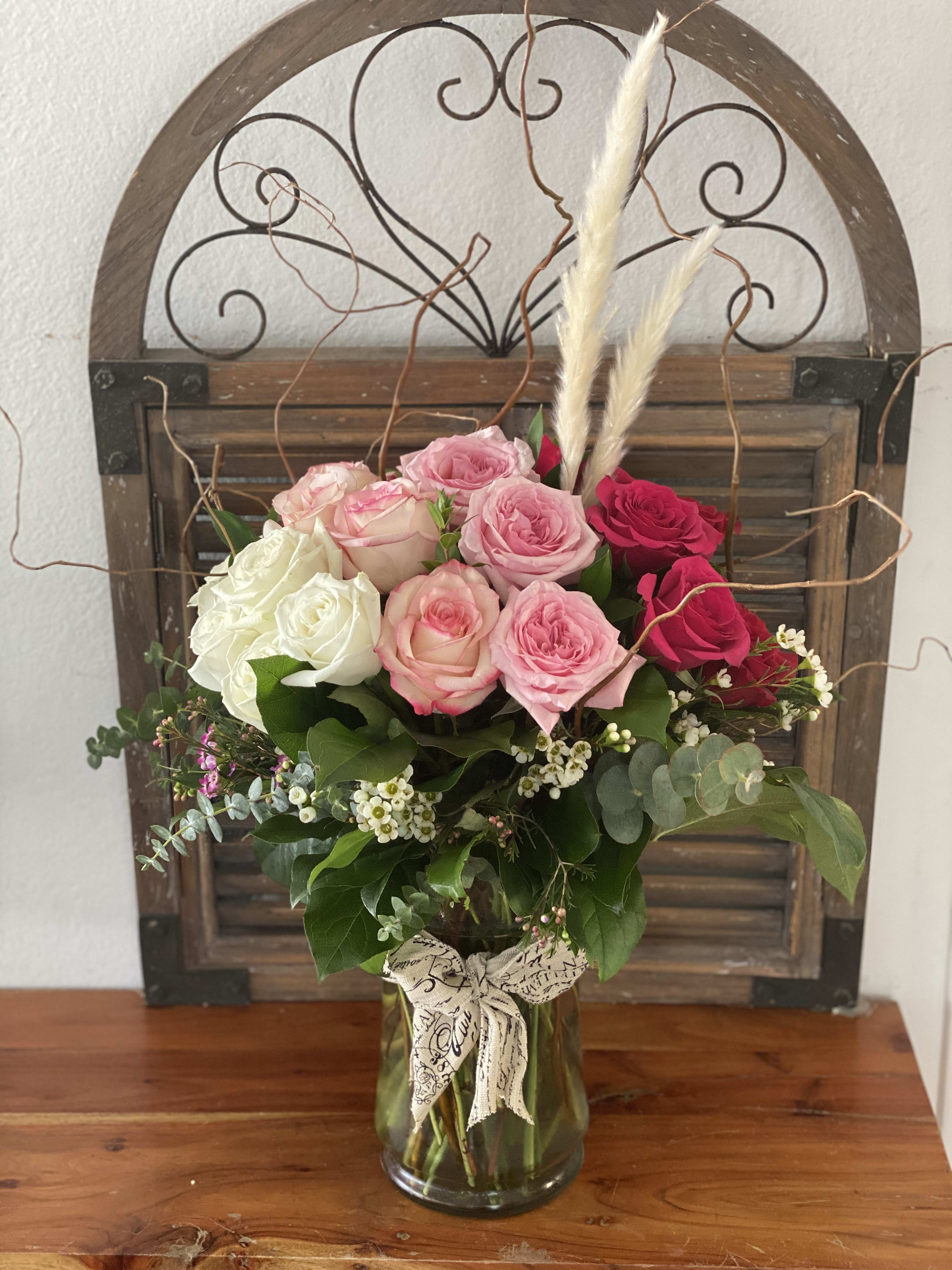 Bouquet of pink, white, and red roses in a glass vase