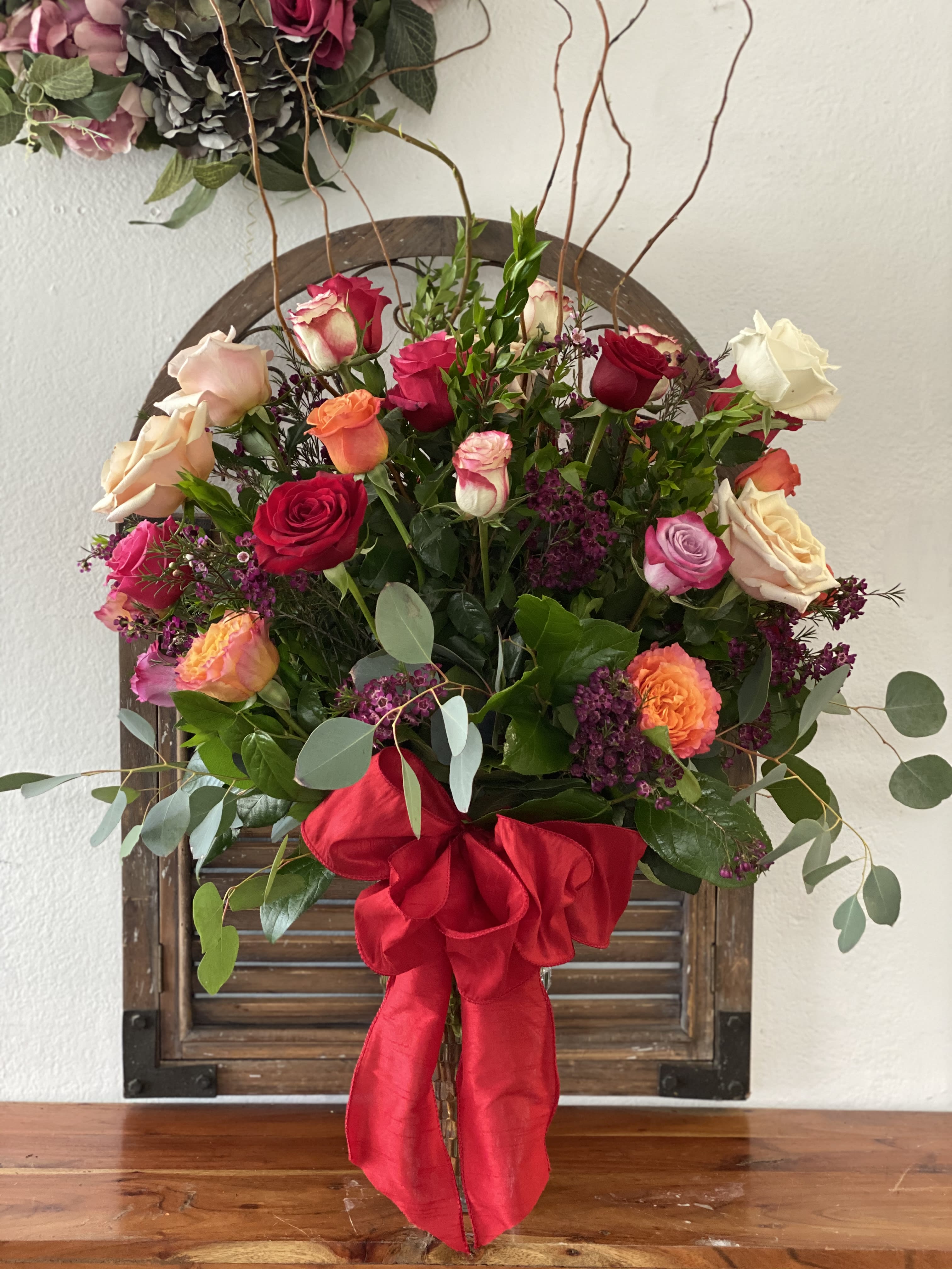 Mixed rose bouquet with a large red ribbon bow