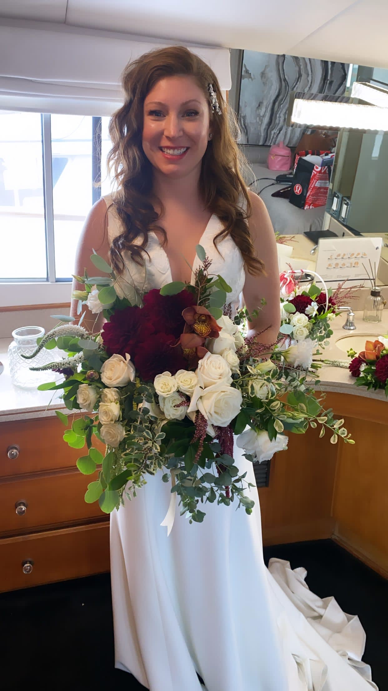 Bride holding a large bouquet of white and burgundy flowers