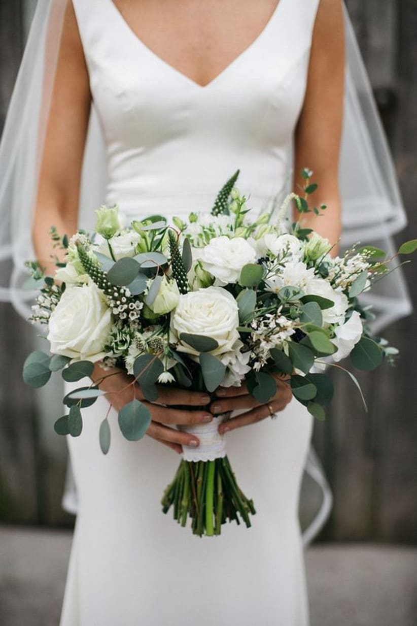 Bride holding a white bouquet with green foliage