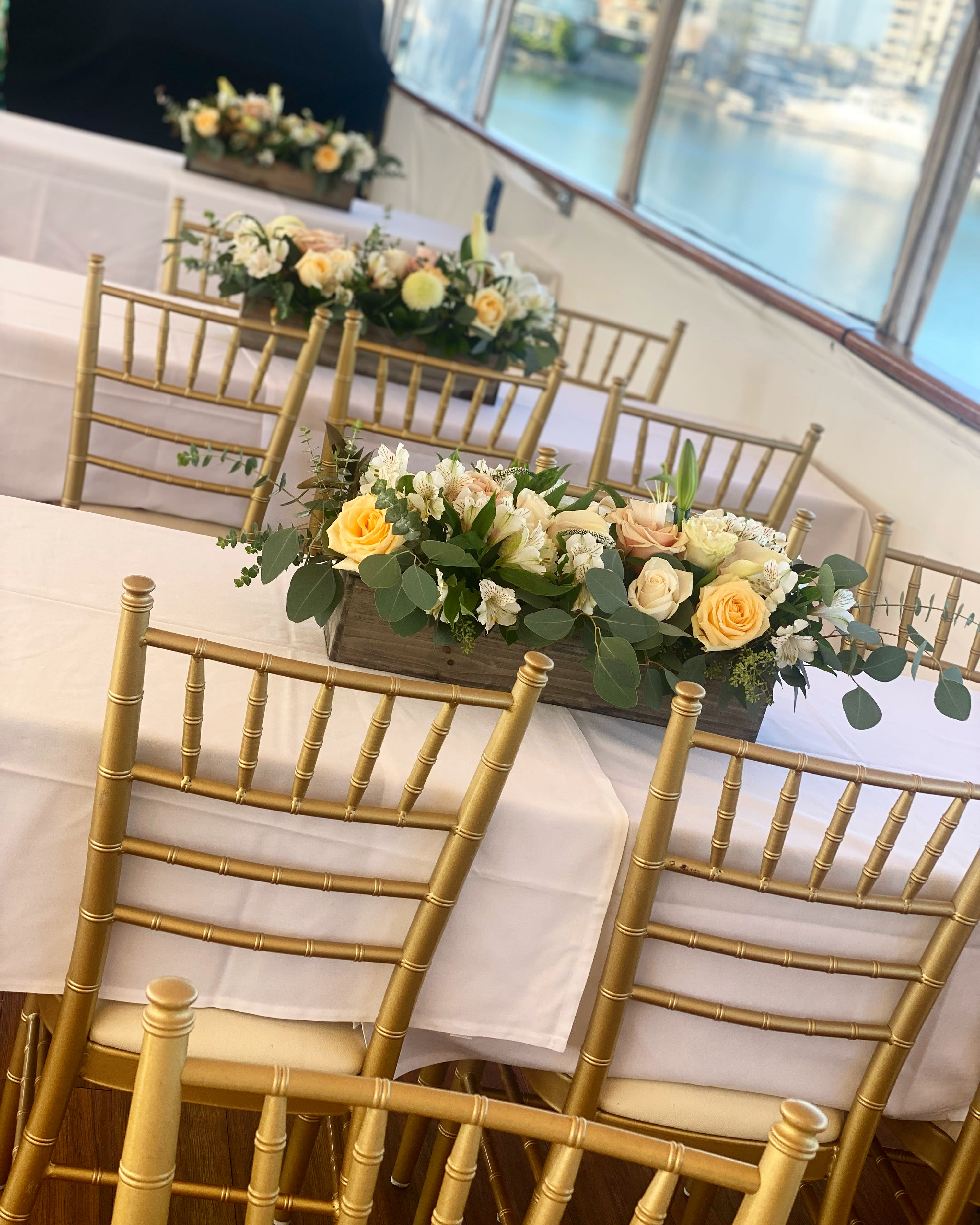 Low floral centerpiece with peach and white roses on a banquet table