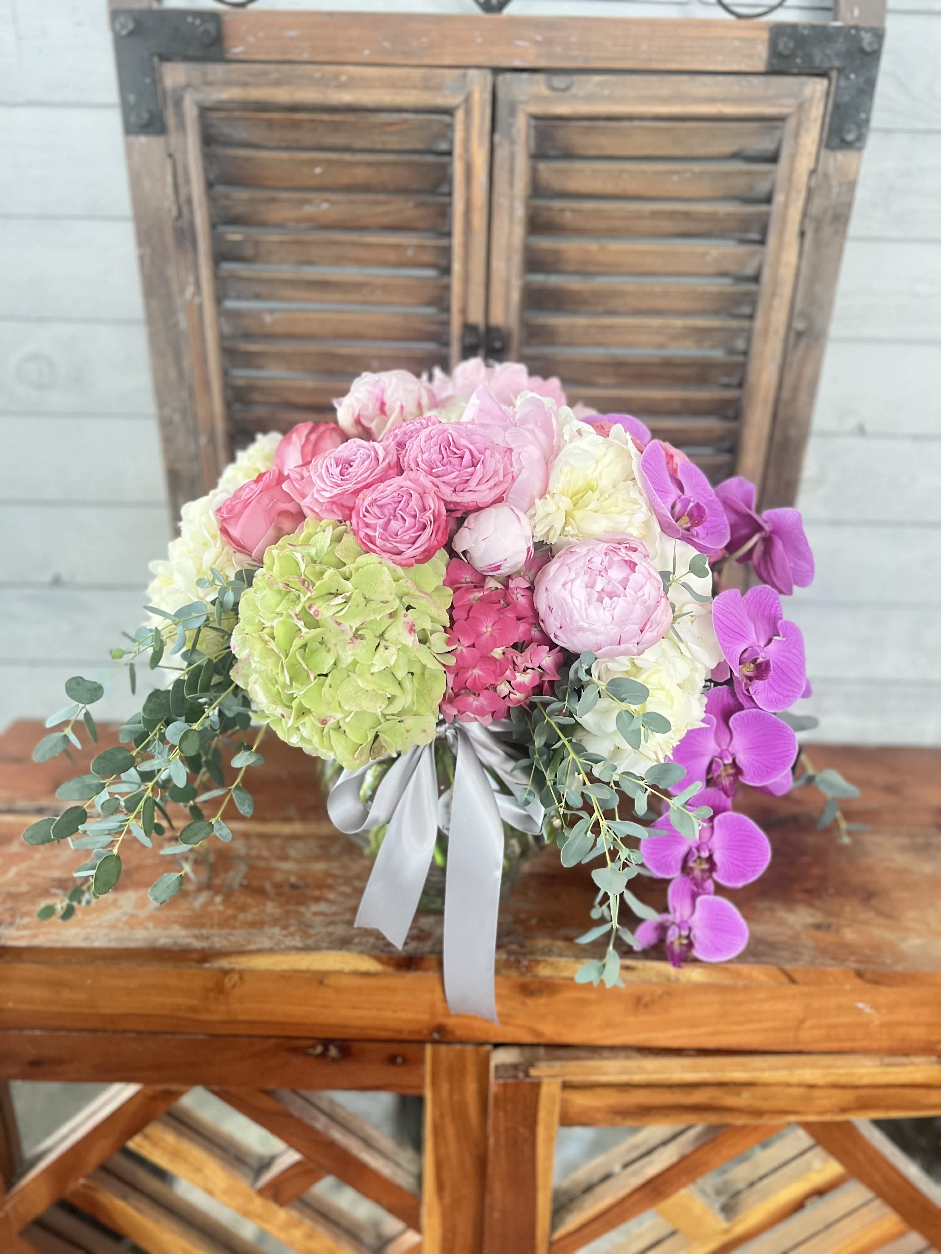 Pink and white floral arrangement with orchids and hydrangeas in a vase