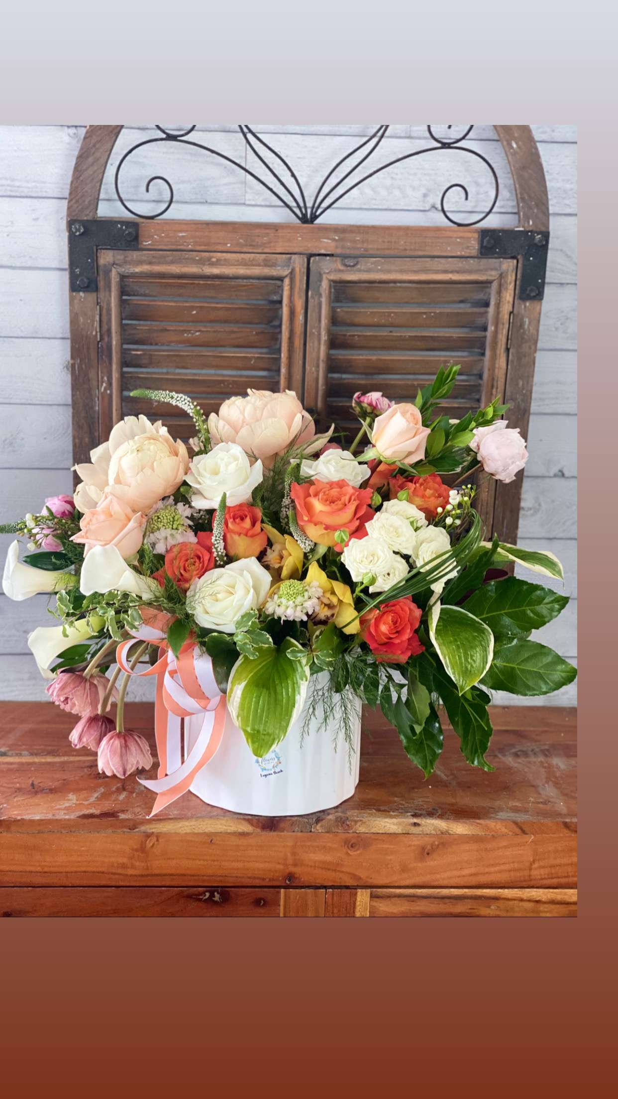 Mixed bouquet in a white hatbox with peach, white, and coral blooms