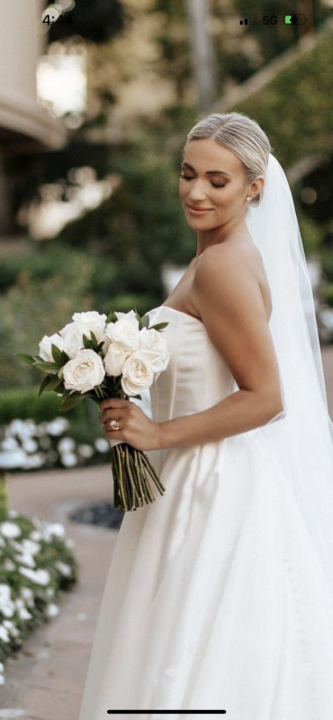 Bride holding a bouquet of white roses in a strapless gown