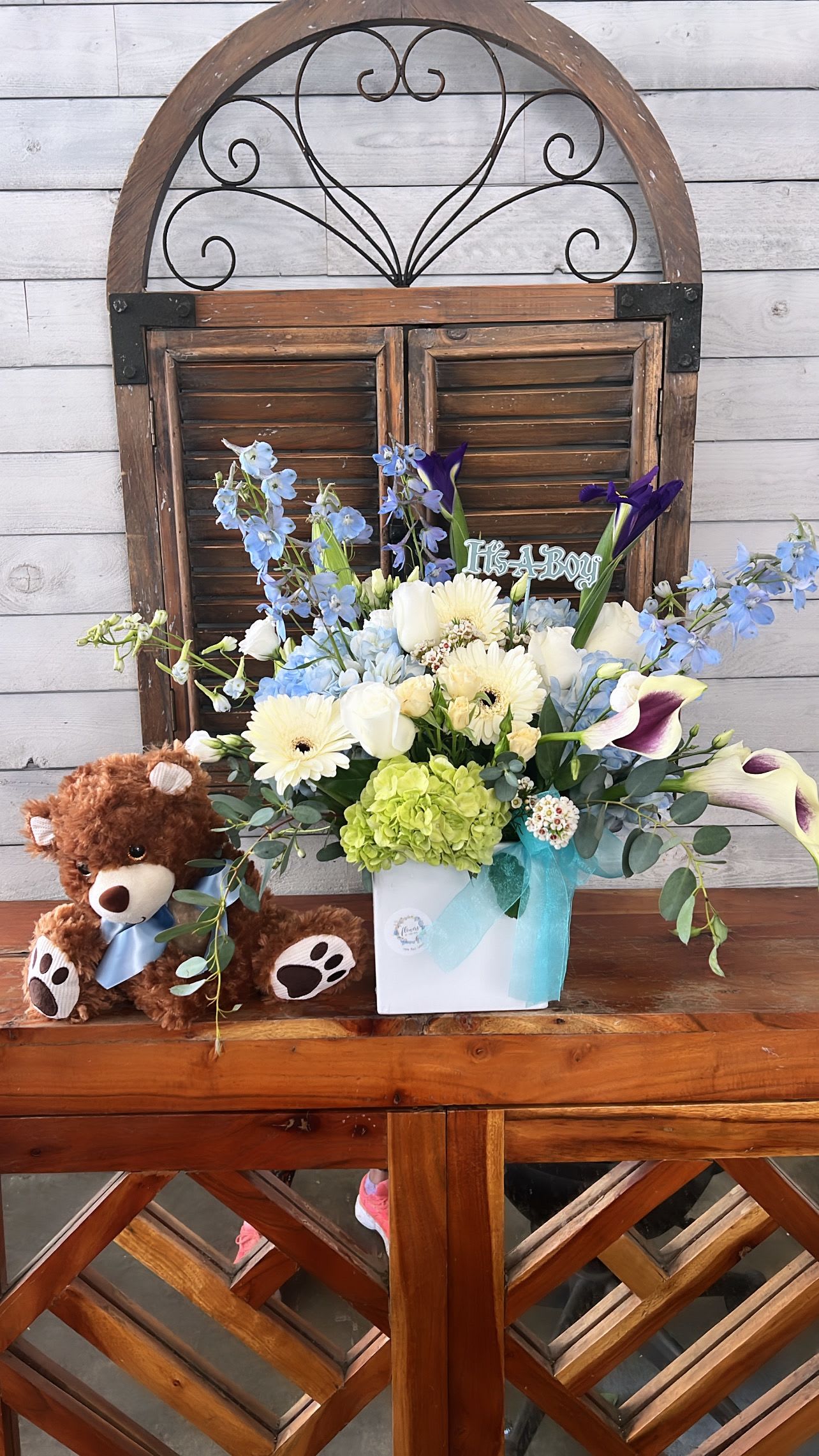 Bouquet in a white box with a teddy bear and blue ribbon