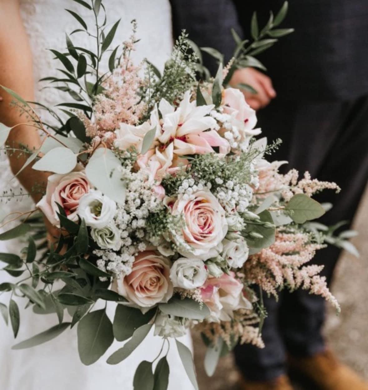 Wedding bouquet of blush roses and white flowers with airy greenery