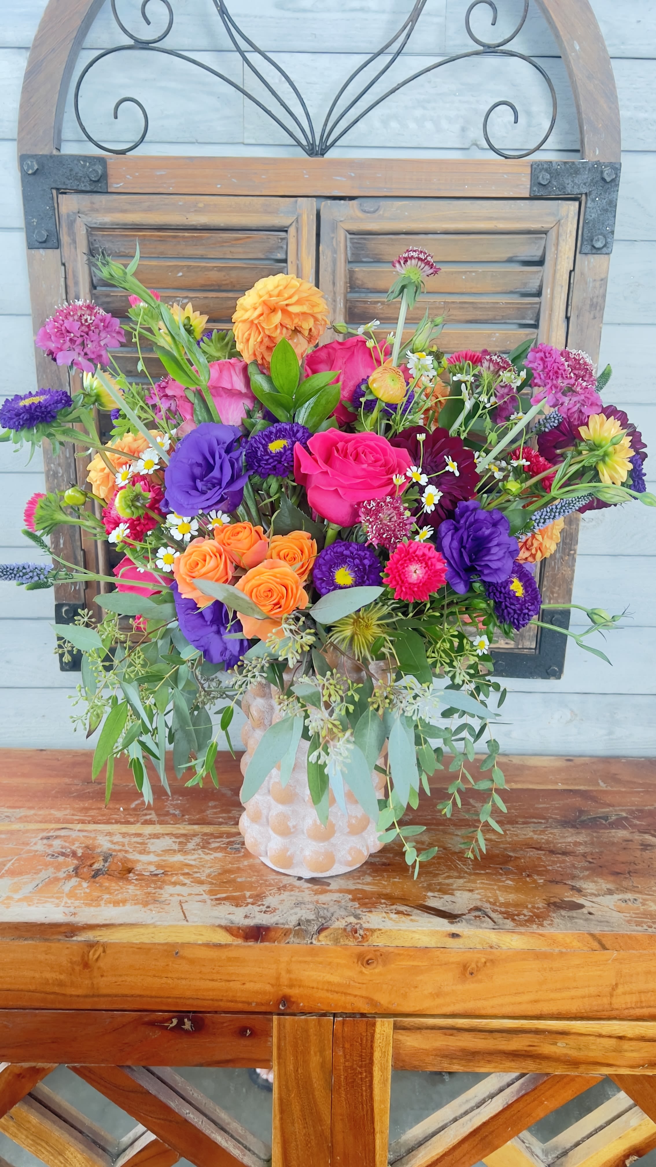 Bright mixed bouquet in a textured vase
