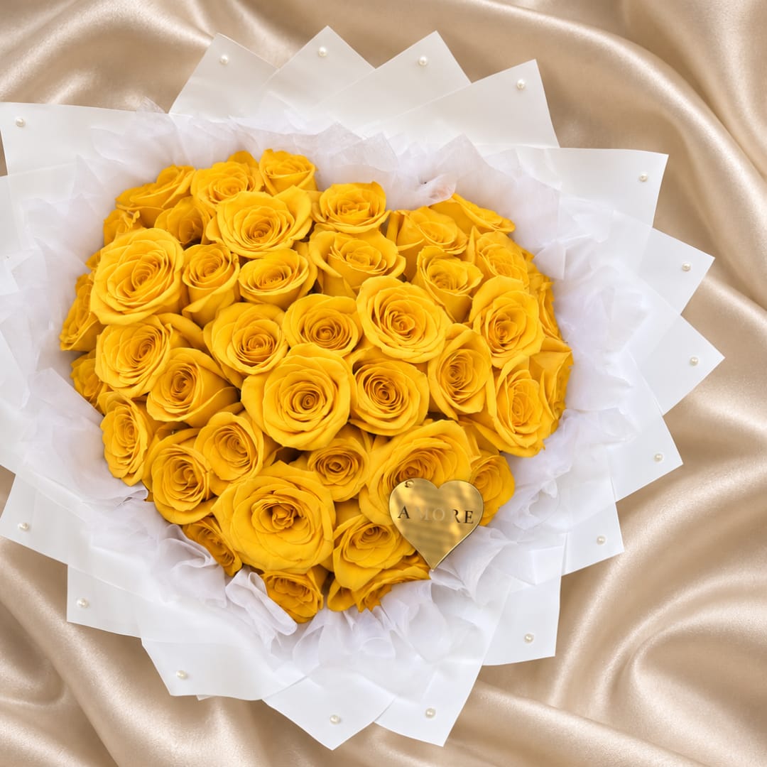 Heart-shaped bouquet of yellow roses wrapped in white paper