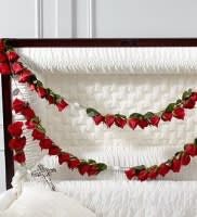 Red rose garlands draped across a white upholstered headboard